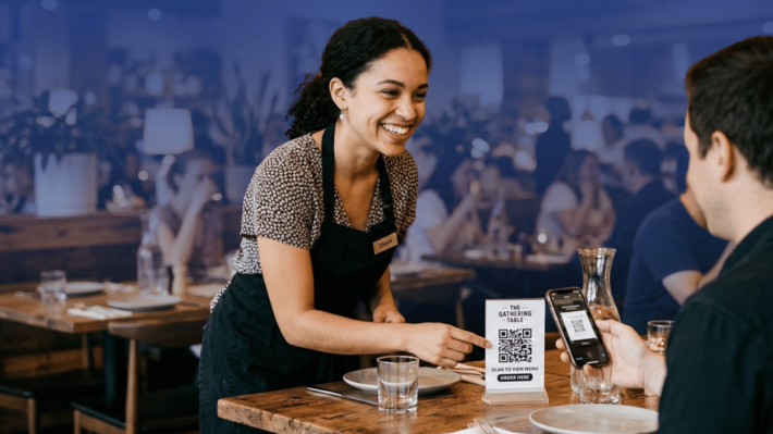 QR Code for Restaurants - image showing staff presenting the QR code to a restaurant client to place an order